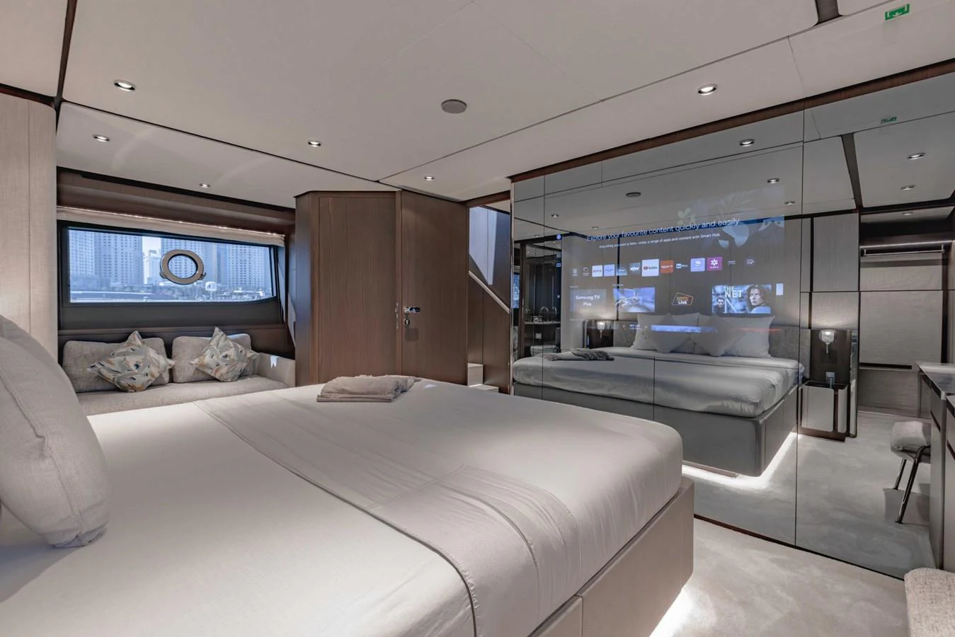 The stateroom features a luxurious bed, mirrored walls, and modern decor, creating a serene and spacious ambiance. aboard CYRUS Yacht for Sale
