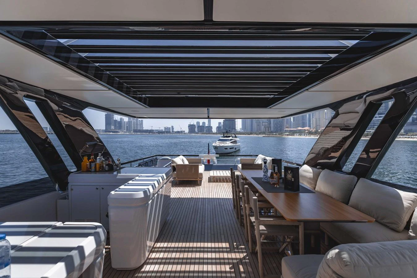 The aft deck features a spacious seating area with a stunning view of the water and skyline. aboard CYRUS Yacht for Sale