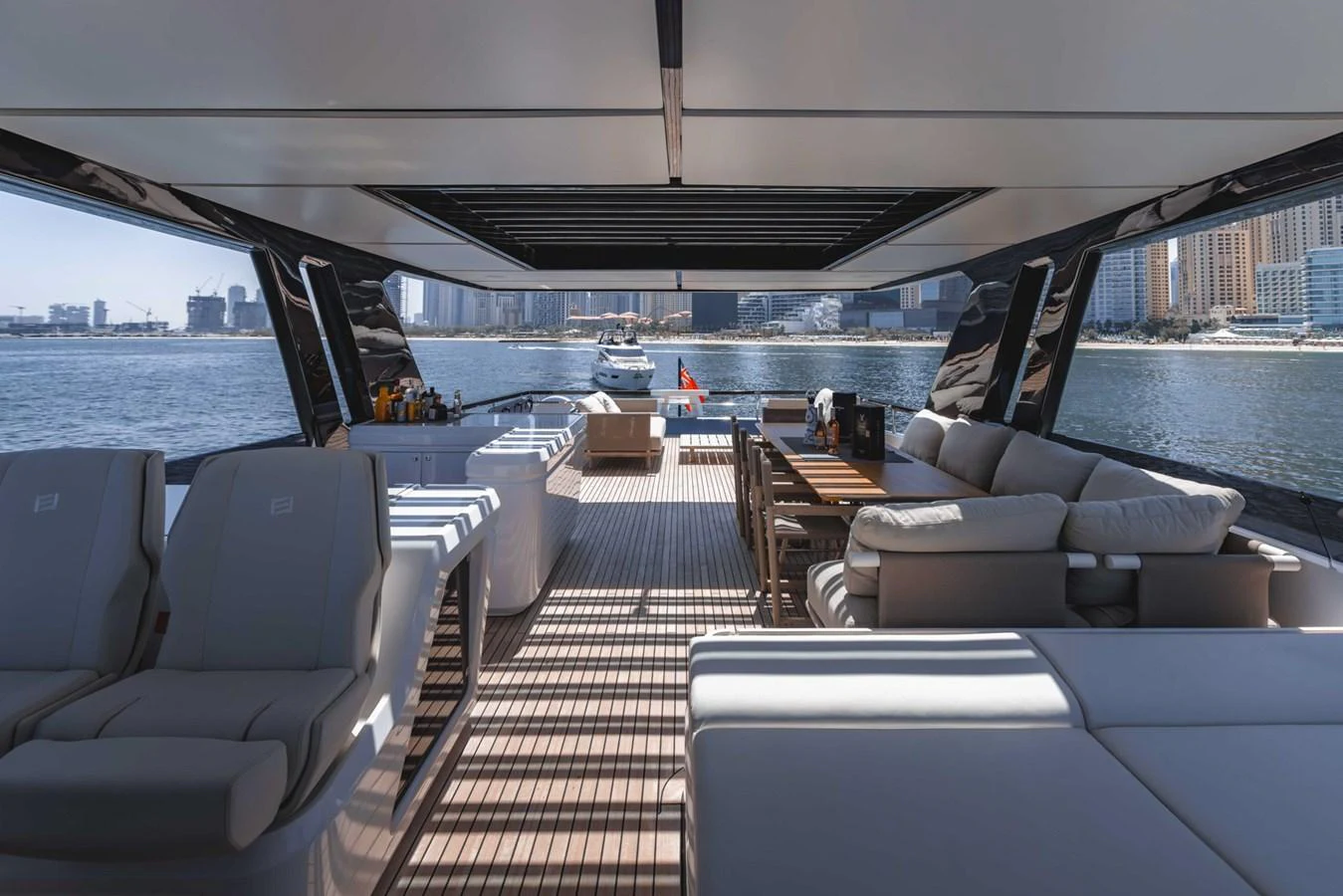 The aft deck offers a spacious and luxurious seating area with stunning views of the water and city skyline. aboard CYRUS Yacht for Sale