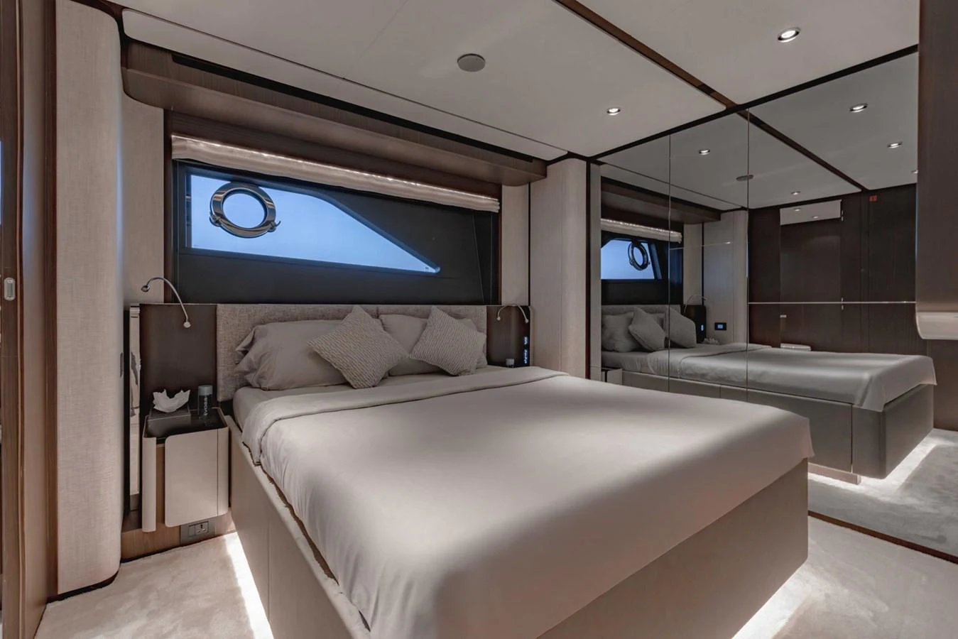 The stateroom features a luxurious bed with elegant bedding and ample natural light from the window. aboard CYRUS Yacht for Sale