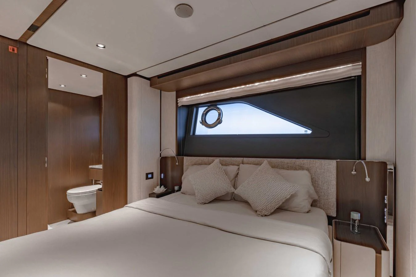 The stateroom features a plush bed with elegant wood paneling and a modern ensuite bathroom. aboard CYRUS Yacht for Sale