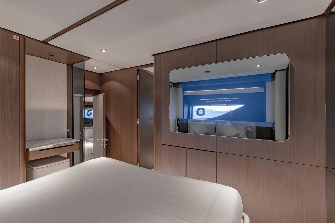 The stateroom features a modern design with sleek wood paneling and a large window offering a serene view. aboard CYRUS Yacht for Sale