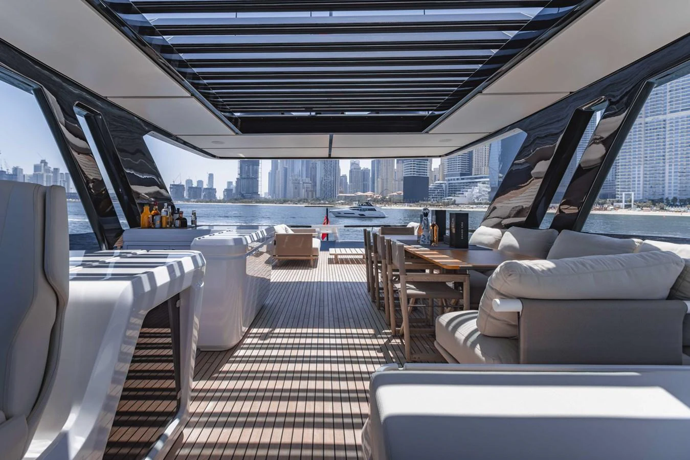 The aft deck offers a luxurious open-air lounge with stunning cityscape views. aboard CYRUS Yacht for Sale