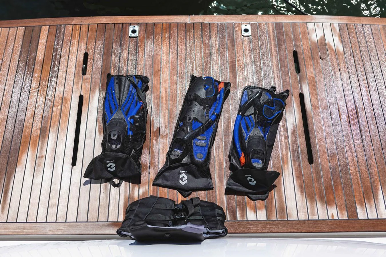 The image showcases a set of diving gear neatly arranged on a wooden deck. aboard CYRUS Yacht for Sale
