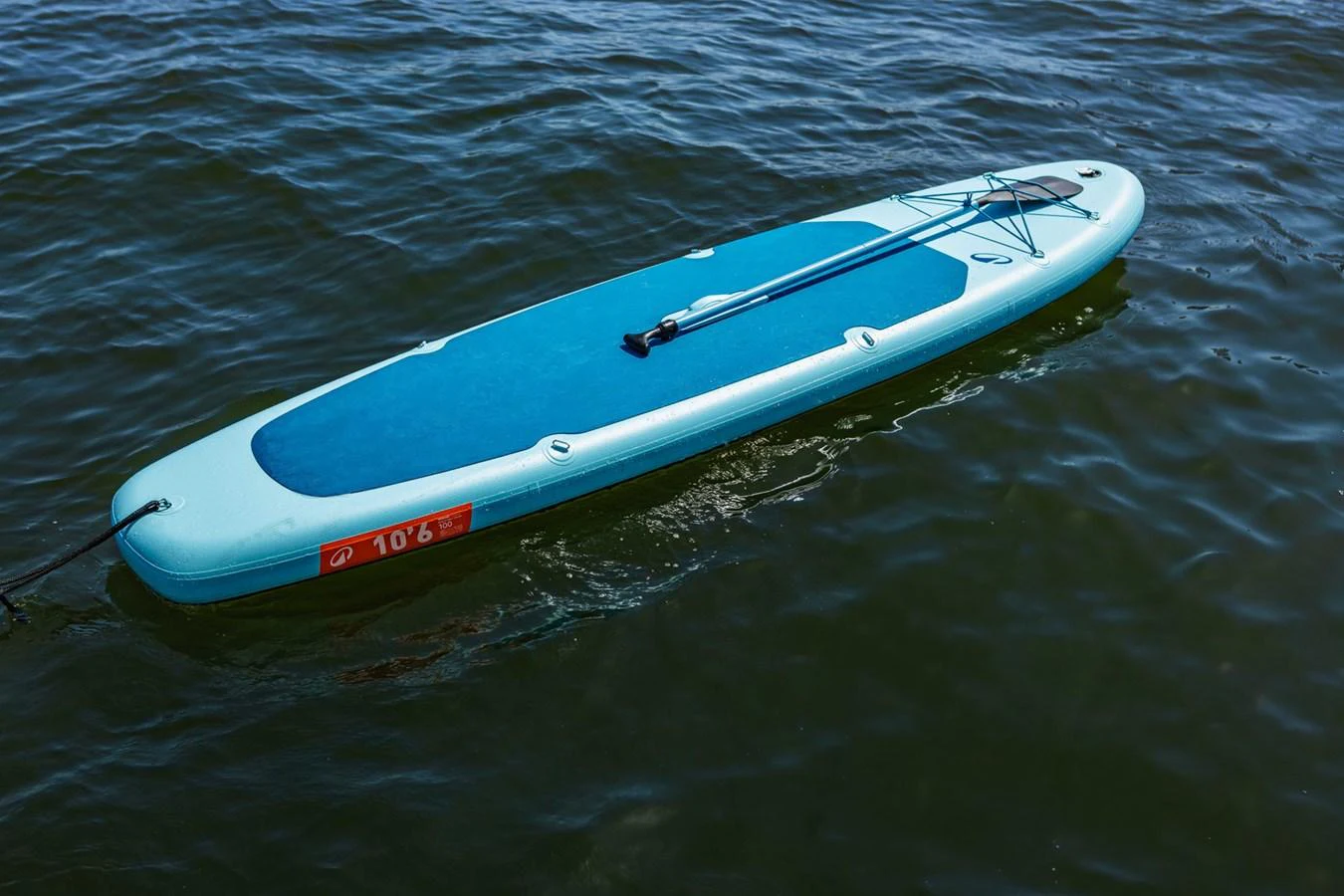 A paddleboard floats on calm waters, ready for adventure. aboard CYRUS Yacht for Sale