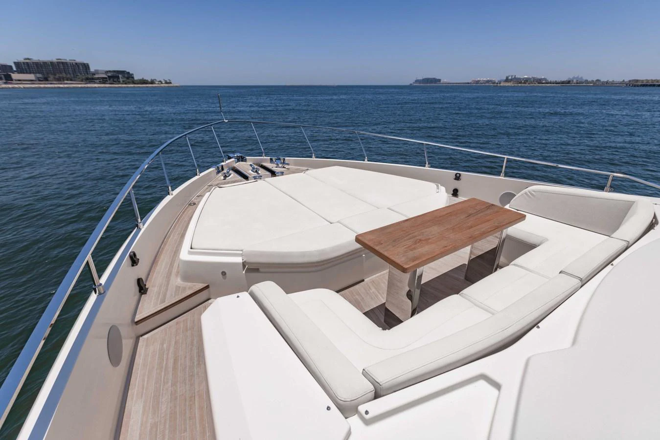The foredeck features a spacious sunbathing area with comfortable seating and a wooden table, perfect for relaxation and enjoying the view. aboard BELLA III Yacht for Sale