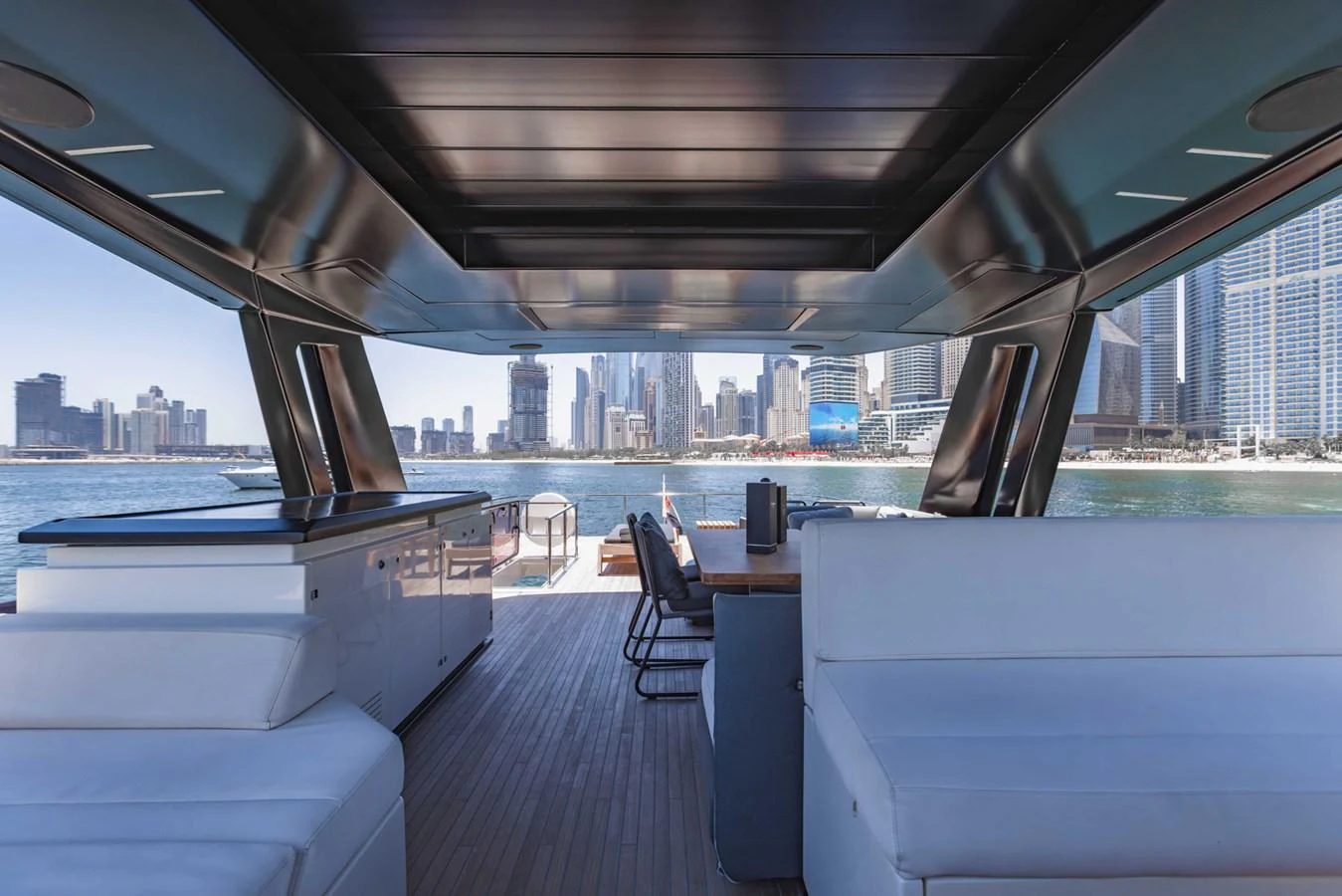 The aft deck offers a spacious and modern seating area with a stunning cityscape view. aboard BELLA III Yacht for Sale