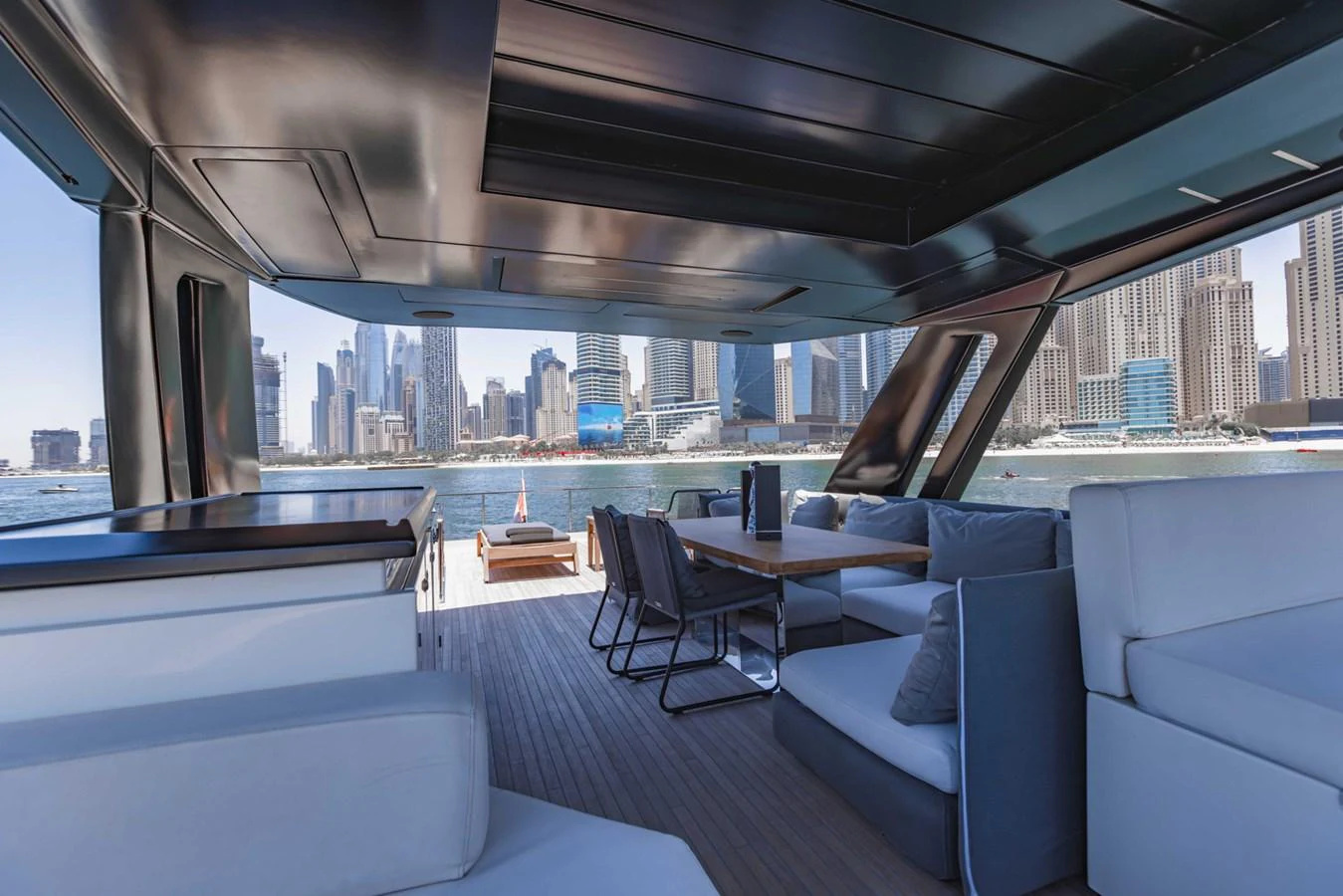 The aft deck offers a spacious and luxurious seating area with a stunning view of the city skyline. aboard BELLA III Yacht for Sale