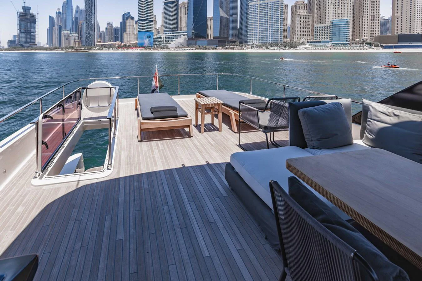 The aft deck offers a spacious and stylish area for relaxation with a stunning cityscape backdrop. aboard BELLA III Yacht for Sale