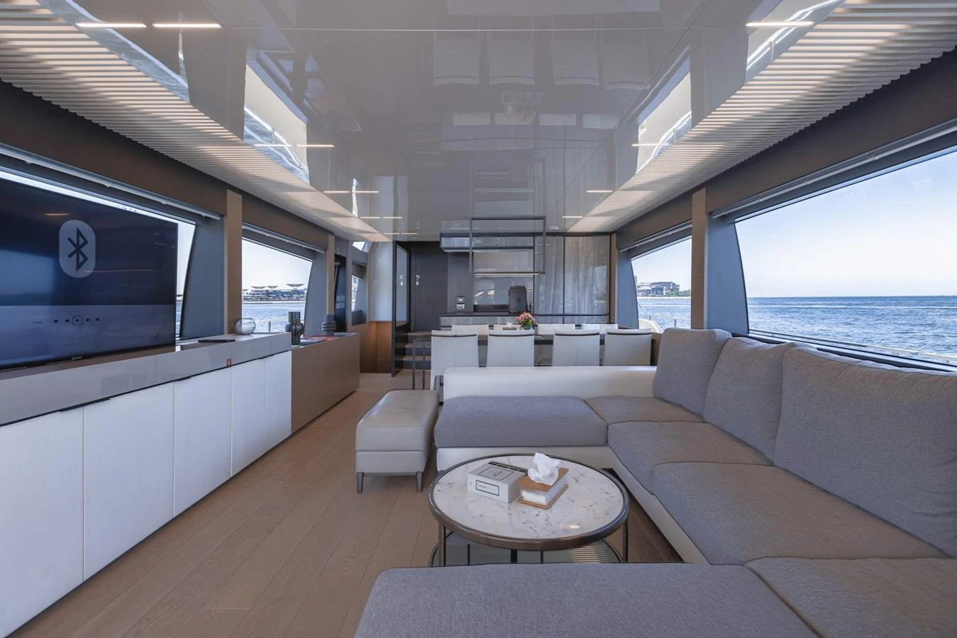 The spacious salon features modern furnishings and panoramic windows offering stunning sea views. aboard BELLA III Yacht for Sale