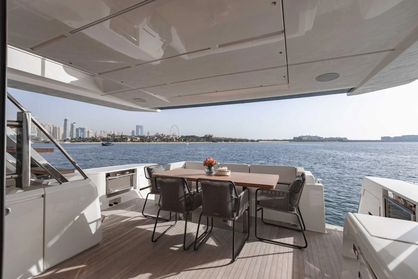 The aft deck offers a spacious dining area with stunning views of the water and city skyline. aboard BELLA III Yacht for Sale