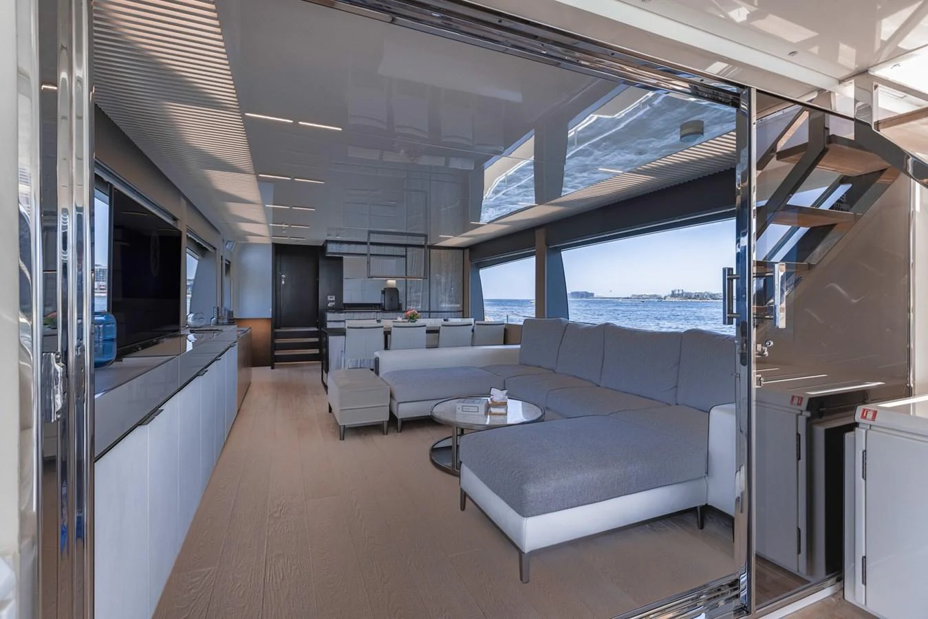 The yacht's salon features a spacious seating area with modern furnishings and large windows offering stunning sea views. aboard BELLA III Yacht for Sale