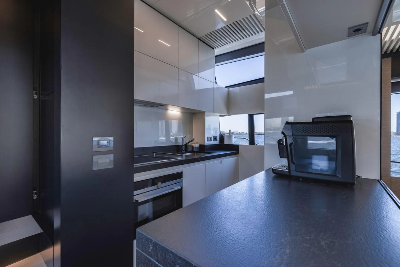 The modern galley features sleek cabinetry and state-of-the-art appliances with a view of the sea. aboard BELLA III Yacht for Sale