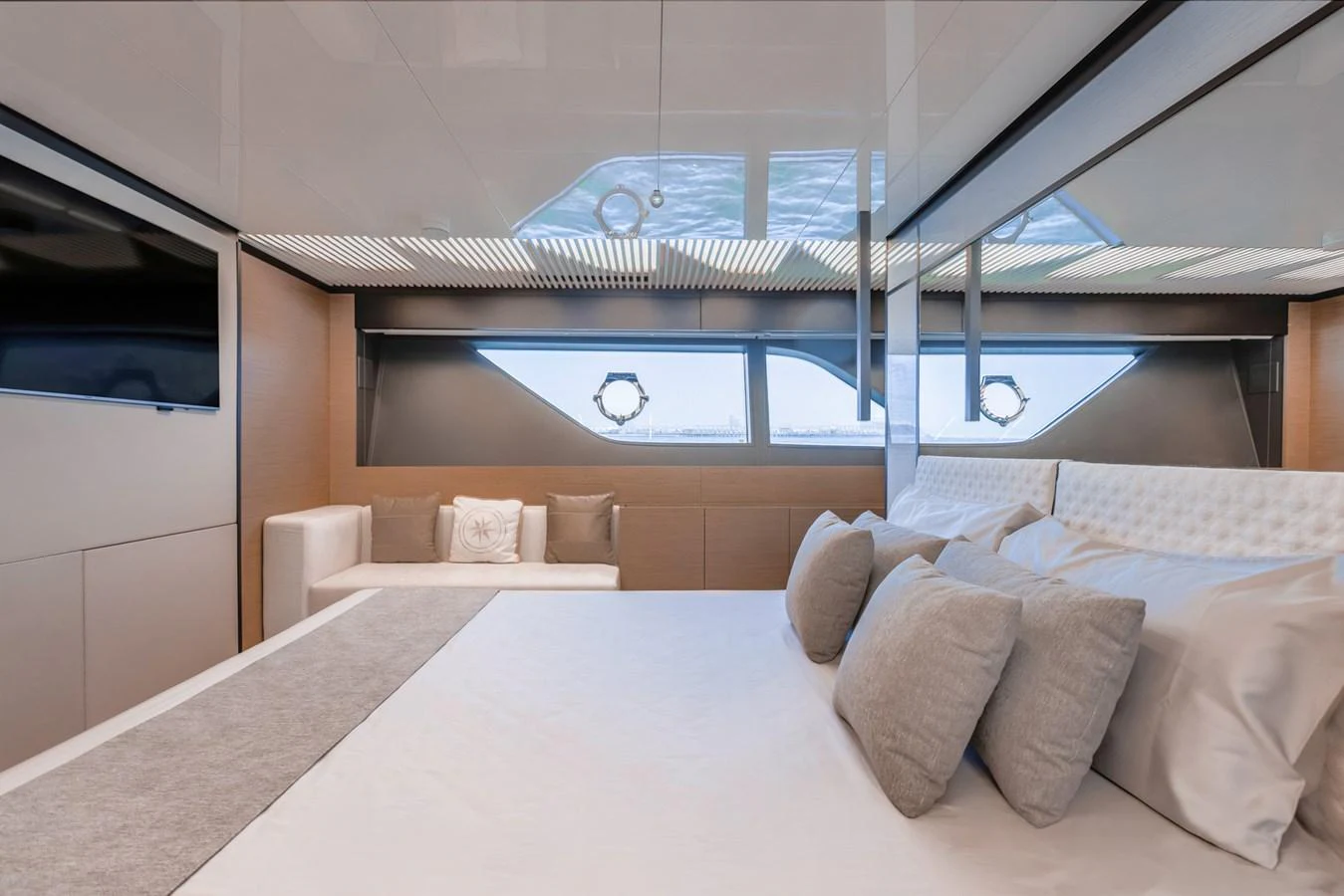 The stateroom features a luxurious bed with plush pillows and a large window offering stunning views. aboard BELLA III Yacht for Sale
