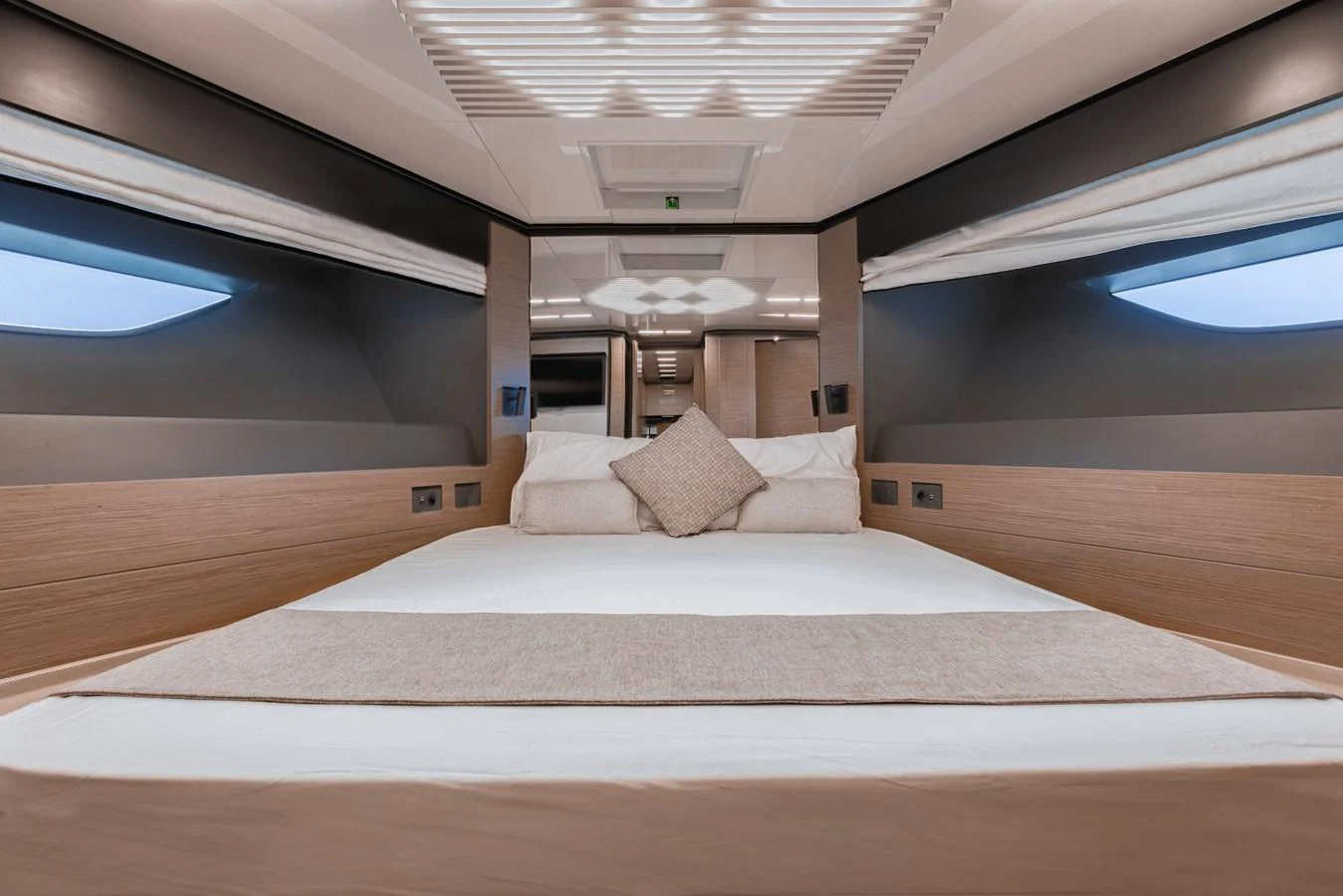 The stateroom features a luxurious bed with modern design elements and ample natural light. aboard BELLA III Yacht for Sale
