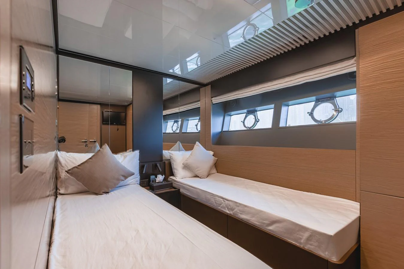 A cozy twin stateroom with modern furnishings and ample natural light. aboard BELLA III Yacht for Sale