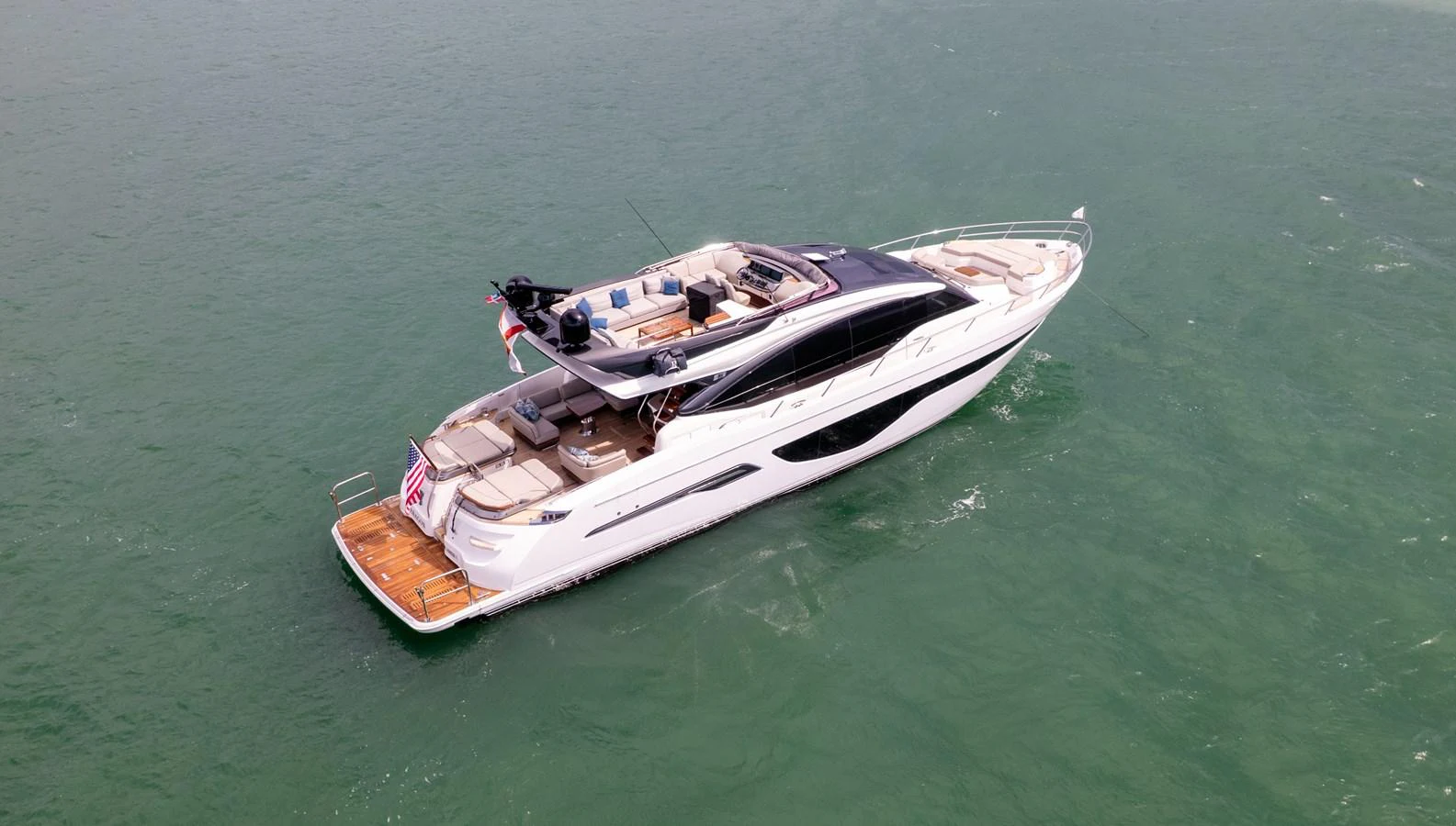 A sleek and modern yacht glides gracefully on calm waters, showcasing its luxurious design and spacious deck areas. aboard PARAGON Yacht for Sale