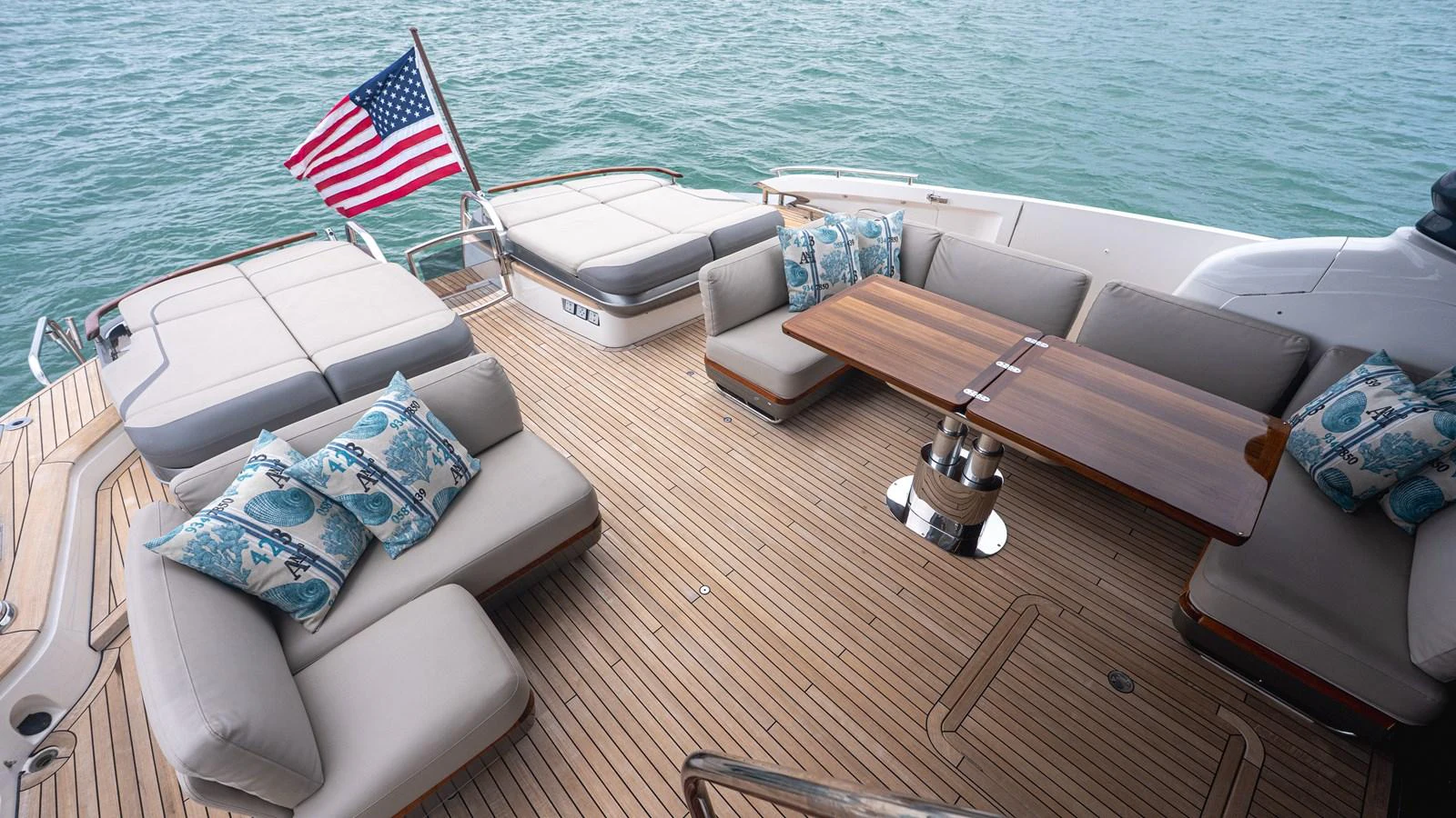 The aft deck features comfortable seating with a wooden table, perfect for relaxing and enjoying the view. aboard PARAGON Yacht for Sale