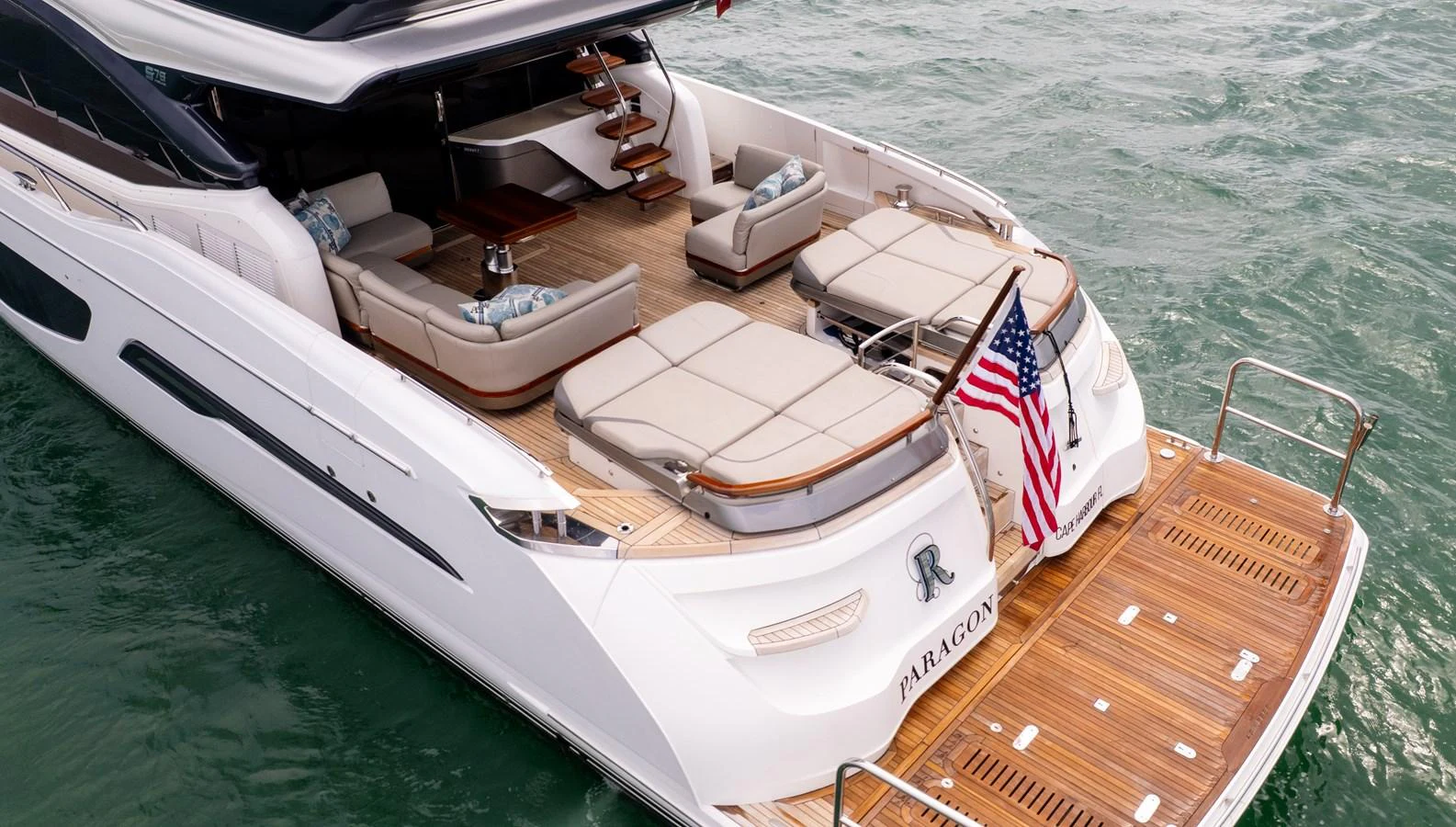 The yacht's aft deck features luxurious seating and a swim platform, perfect for relaxation and water activities. aboard PARAGON Yacht for Sale