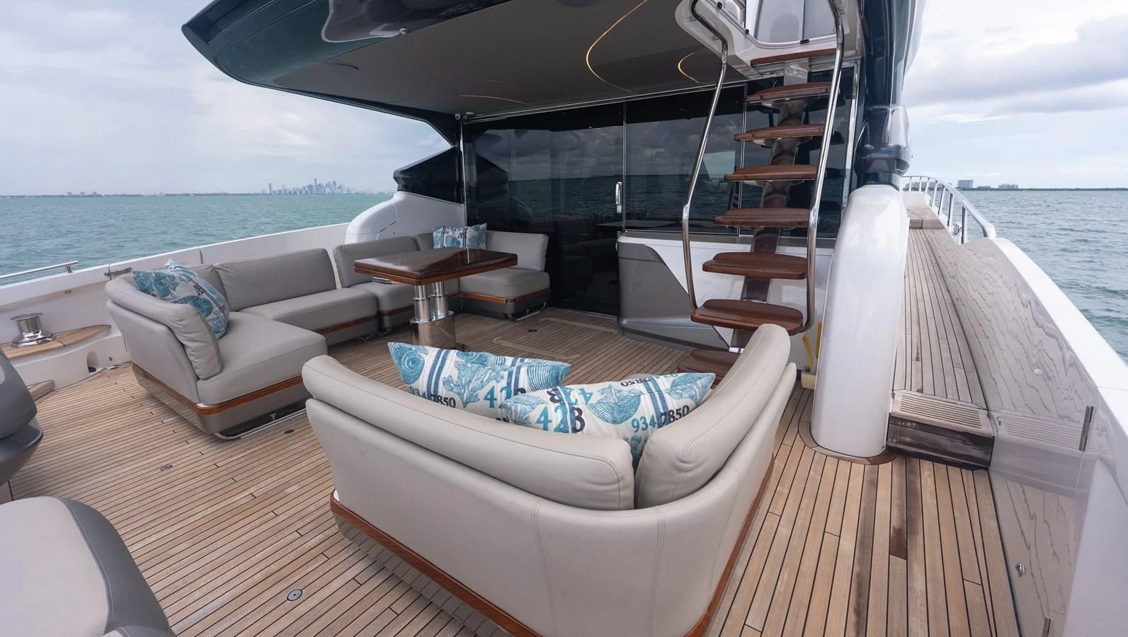 The aft deck features comfortable seating and a stylish staircase leading to the upper deck. aboard PARAGON Yacht for Sale