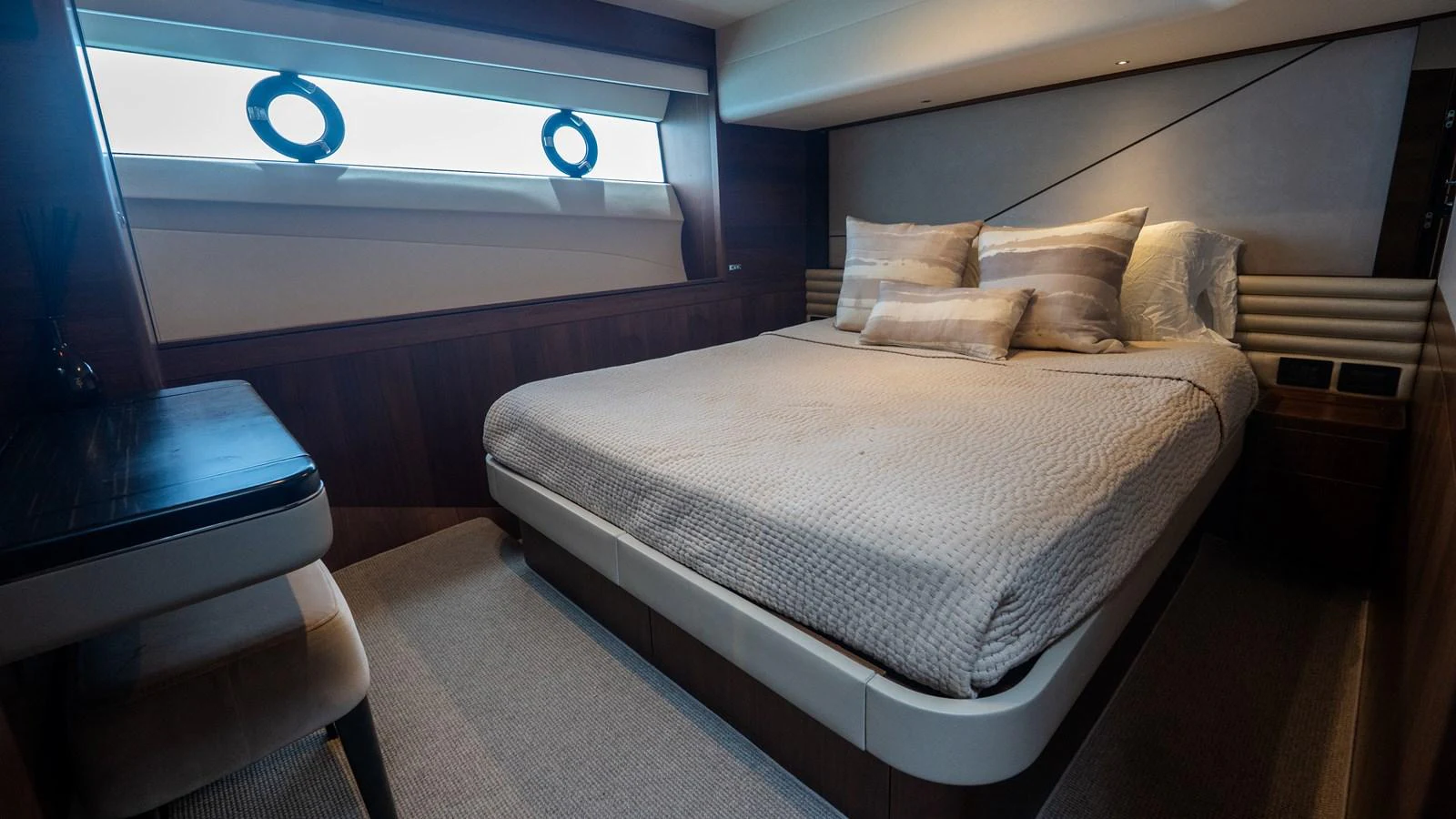 The stateroom features a comfortable bed with elegant bedding and ample natural light from the window. aboard PARAGON Yacht for Sale
