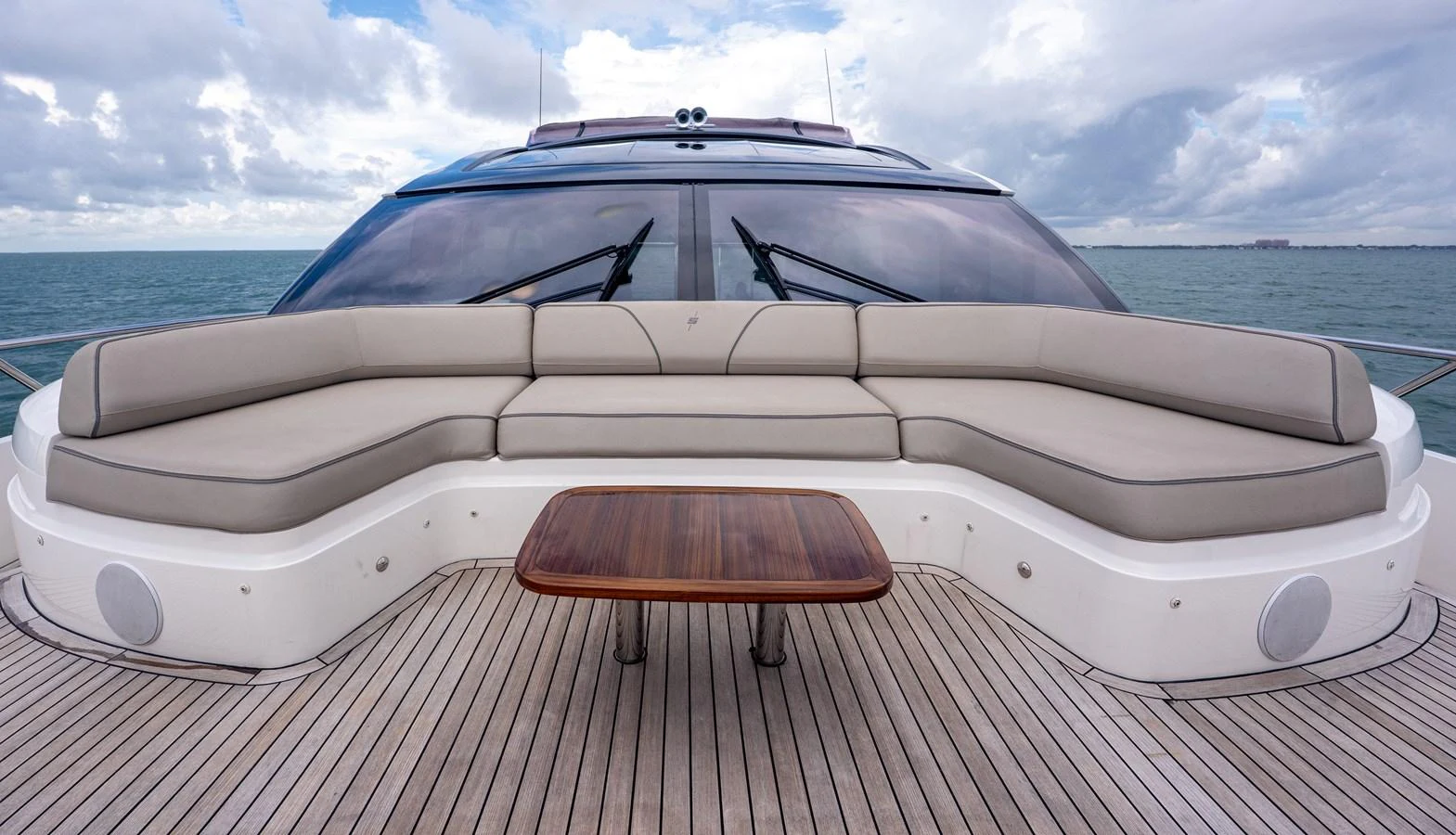 The aft deck features a spacious seating area with a central wooden table, perfect for relaxation and socializing. aboard PARAGON Yacht for Sale