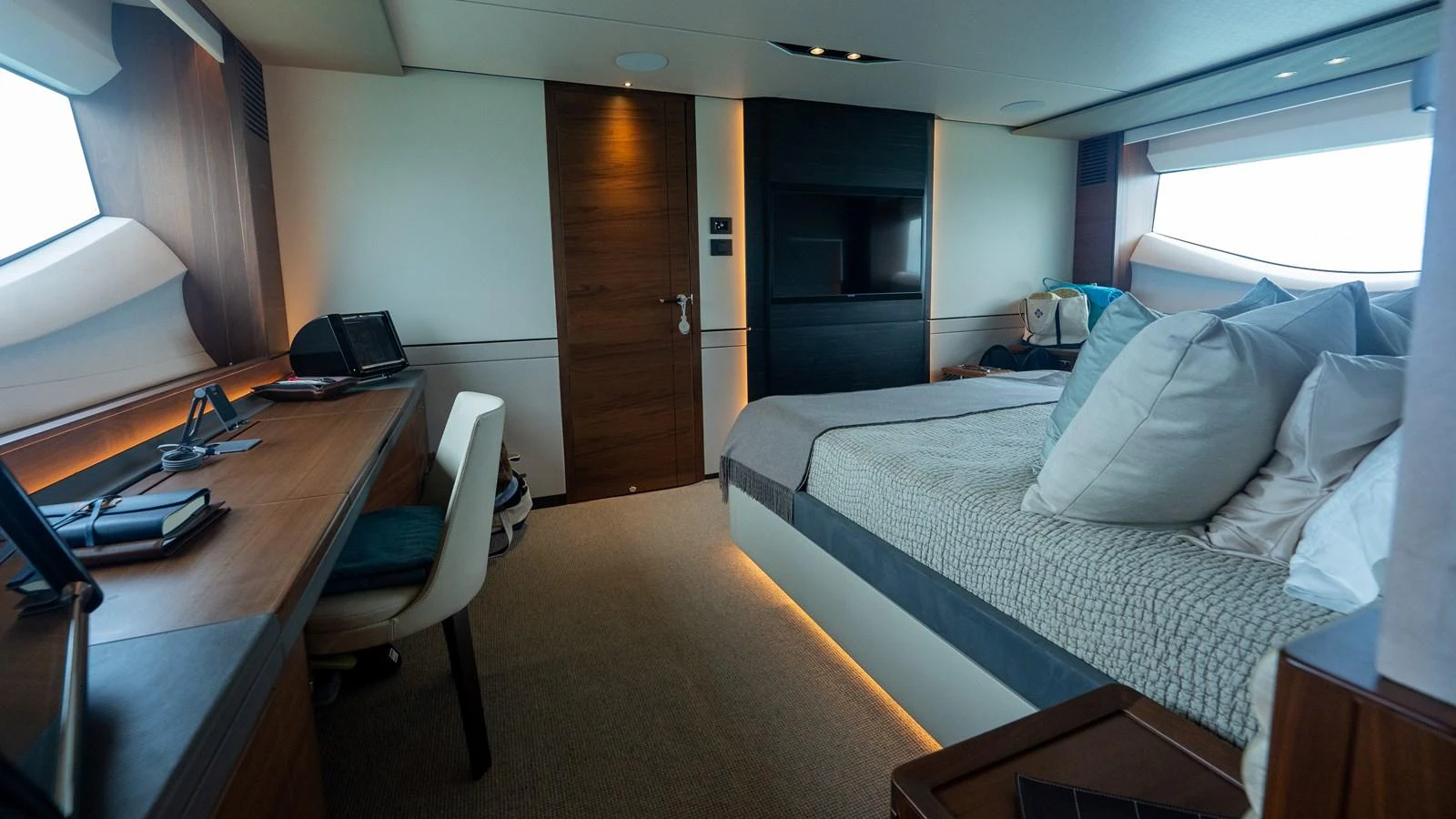 The stateroom features a luxurious bed, a work desk, and ample natural light from large windows. aboard PARAGON Yacht for Sale