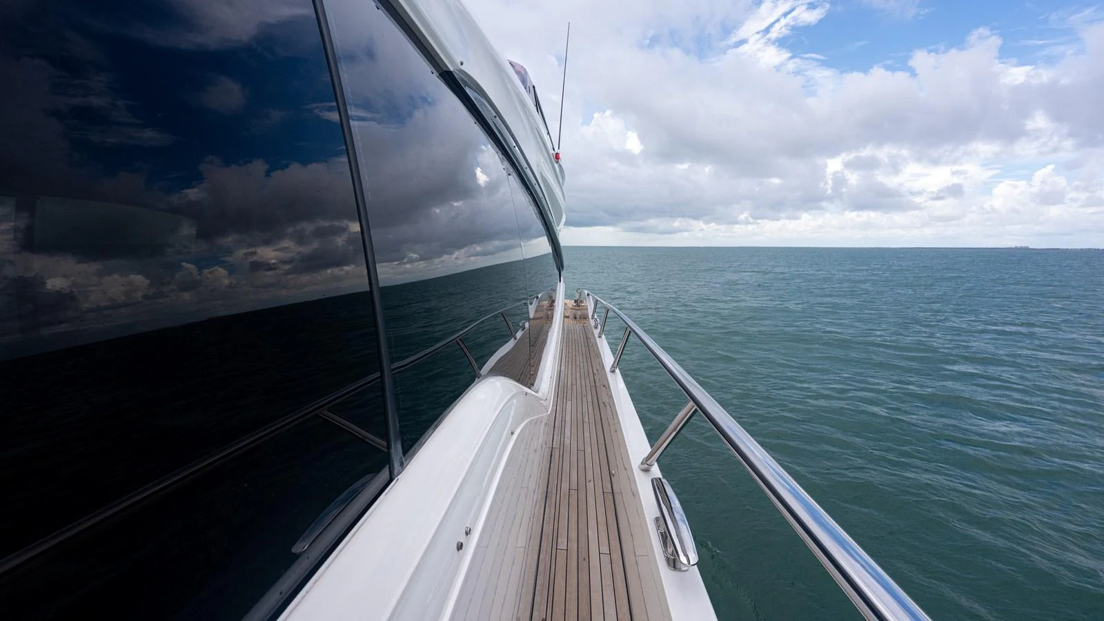 A sleek yacht cruising on open waters under a partly cloudy sky. aboard PARAGON Yacht for Sale