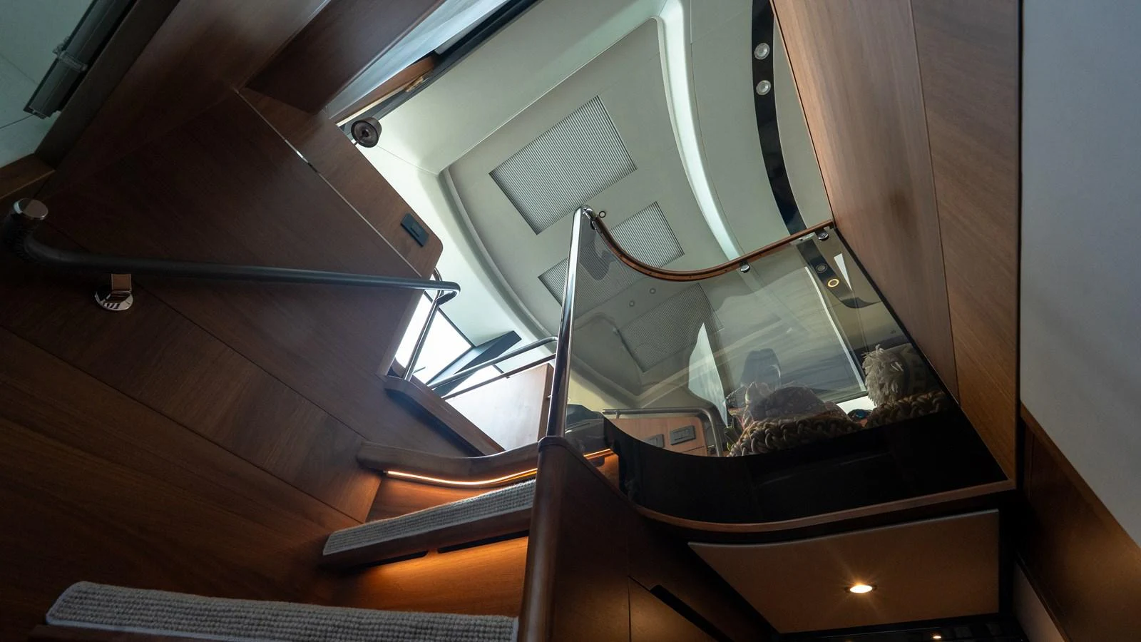 A stylish staircase leads to the upper deck, showcasing modern design and warm wood finishes. aboard PARAGON Yacht for Sale
