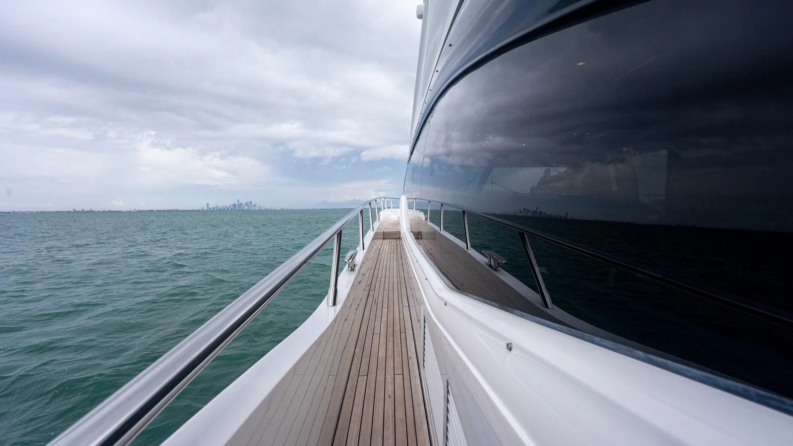 A sleek yacht glides through calm waters, reflecting the horizon on its polished exterior. aboard PARAGON Yacht for Sale