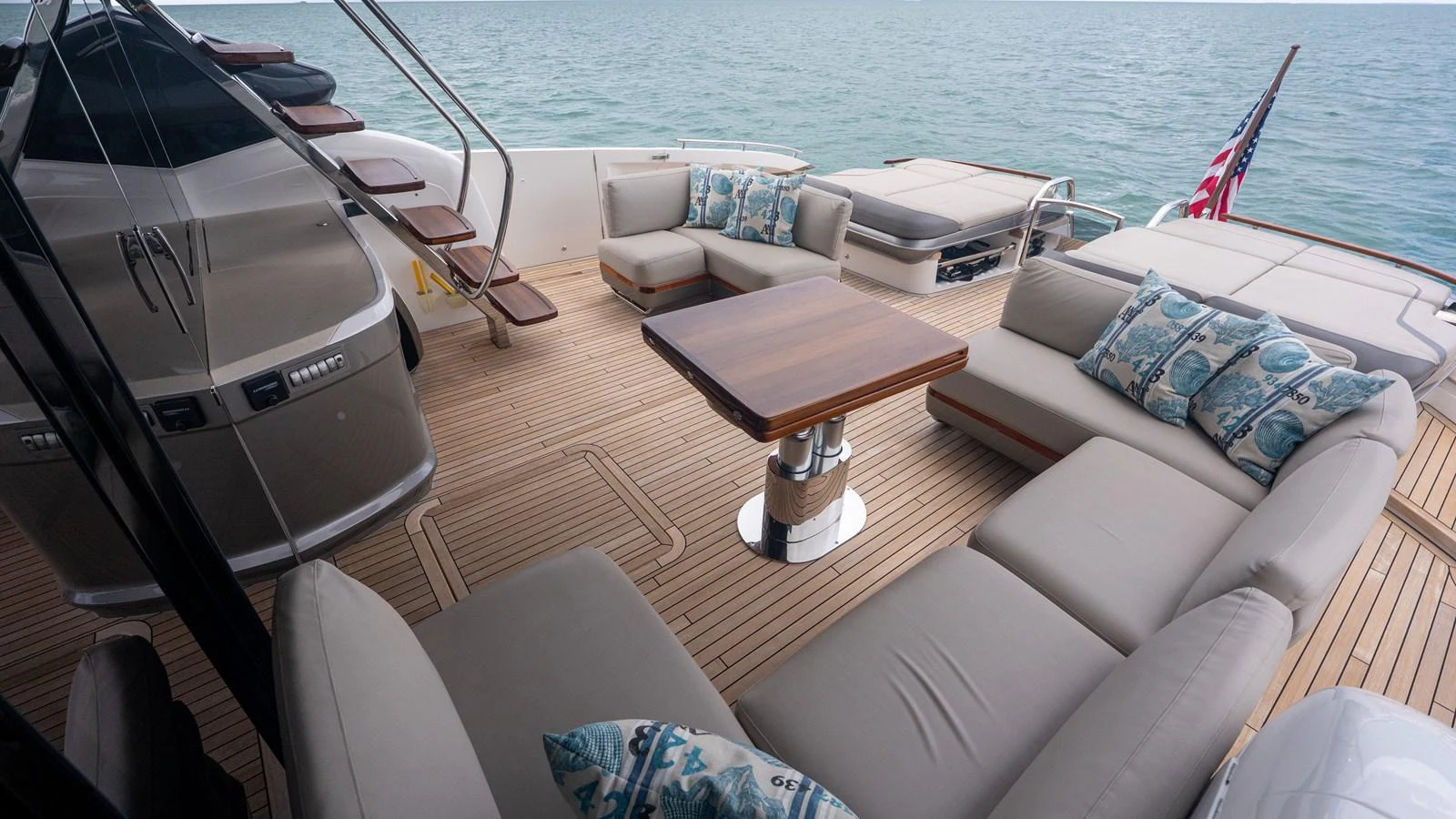 The aft deck features a spacious seating area with plush cushions and a central table, perfect for outdoor relaxation. aboard PARAGON Yacht for Sale