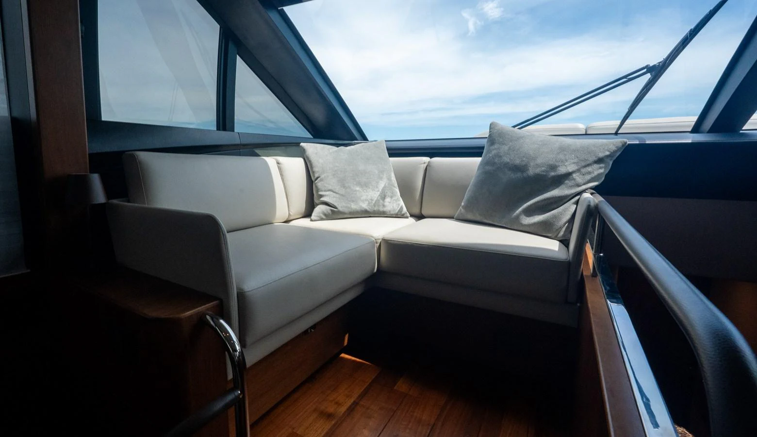 A cozy seating area with plush cushions and large windows offering a view of the sky. aboard PARAGON Yacht for Sale
