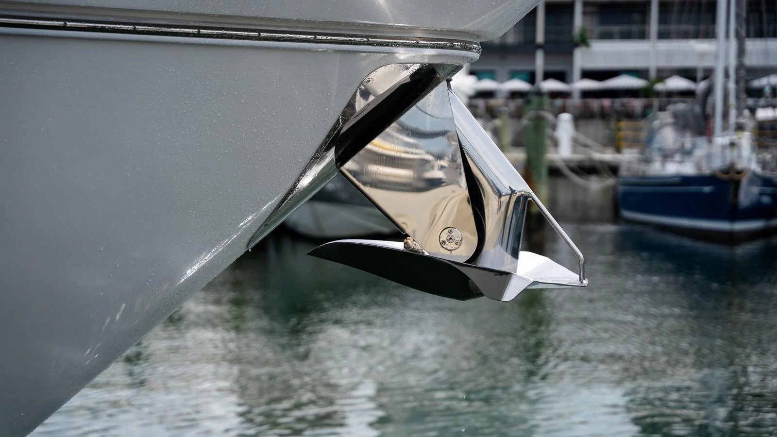 A close-up view of a polished anchor on the bow of a yacht, reflecting the surrounding marina. aboard PARAGON Yacht for Sale