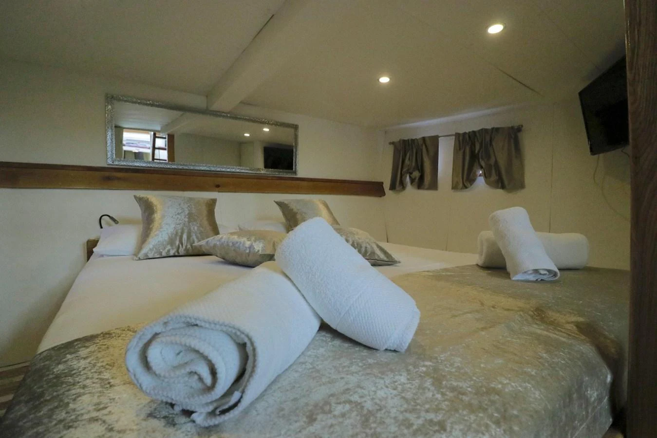 The stateroom features a cozy and inviting bed with plush pillows and neatly rolled towels. aboard 21 M MOTORSAILOR Yacht for Sale
