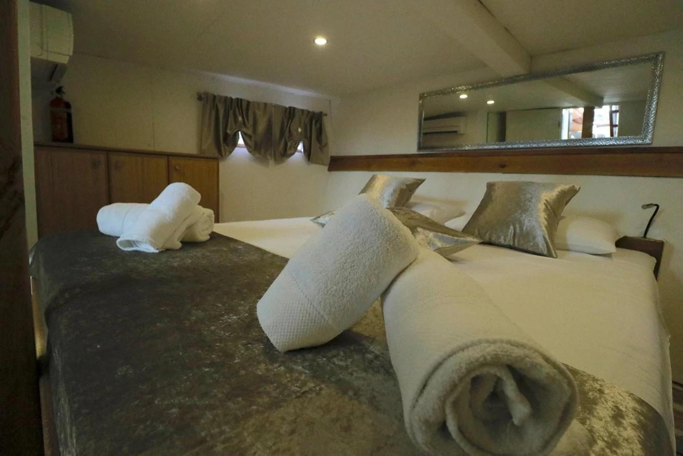The stateroom features a plush bed with elegant pillows and neatly rolled towels, creating a cozy and inviting atmosphere. aboard 21 M MOTORSAILOR Yacht for Sale