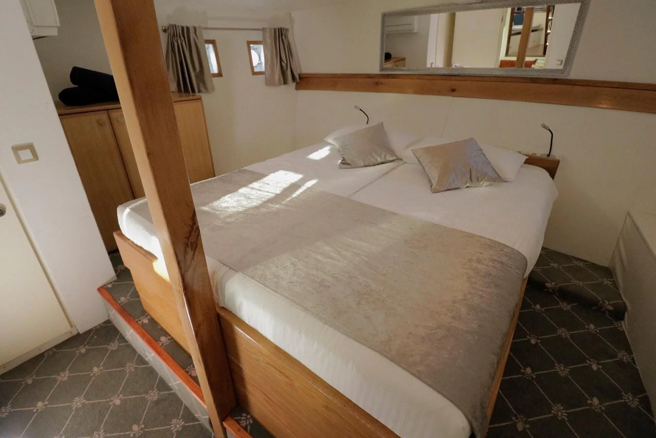 The stateroom features a cozy double bed with elegant bedding and ample natural light. aboard 21 M MOTORSAILOR Yacht for Sale
