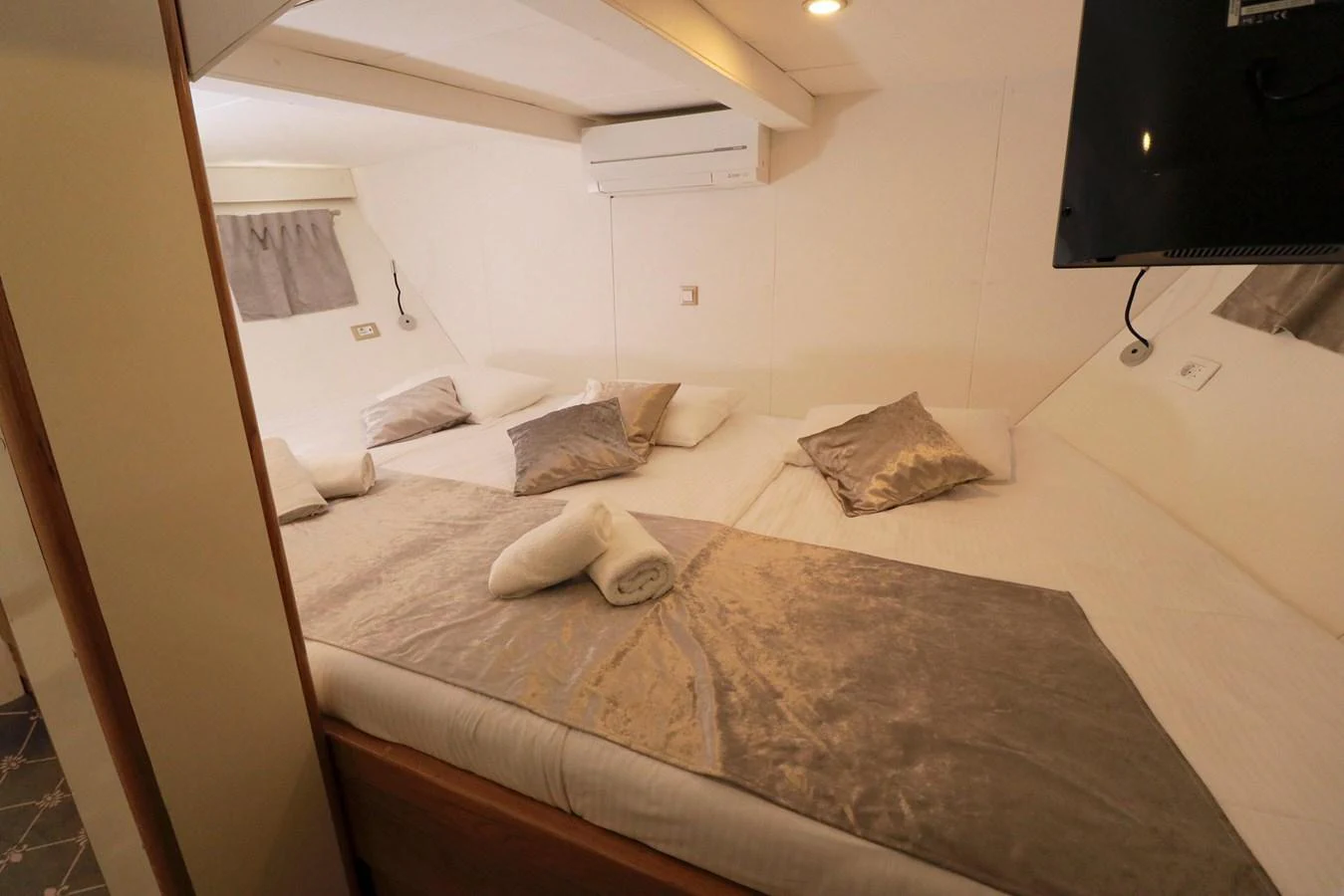 The stateroom features a cozy bed with plush pillows and a neatly folded towel, creating a welcoming atmosphere. aboard 21 M MOTORSAILOR Yacht for Sale