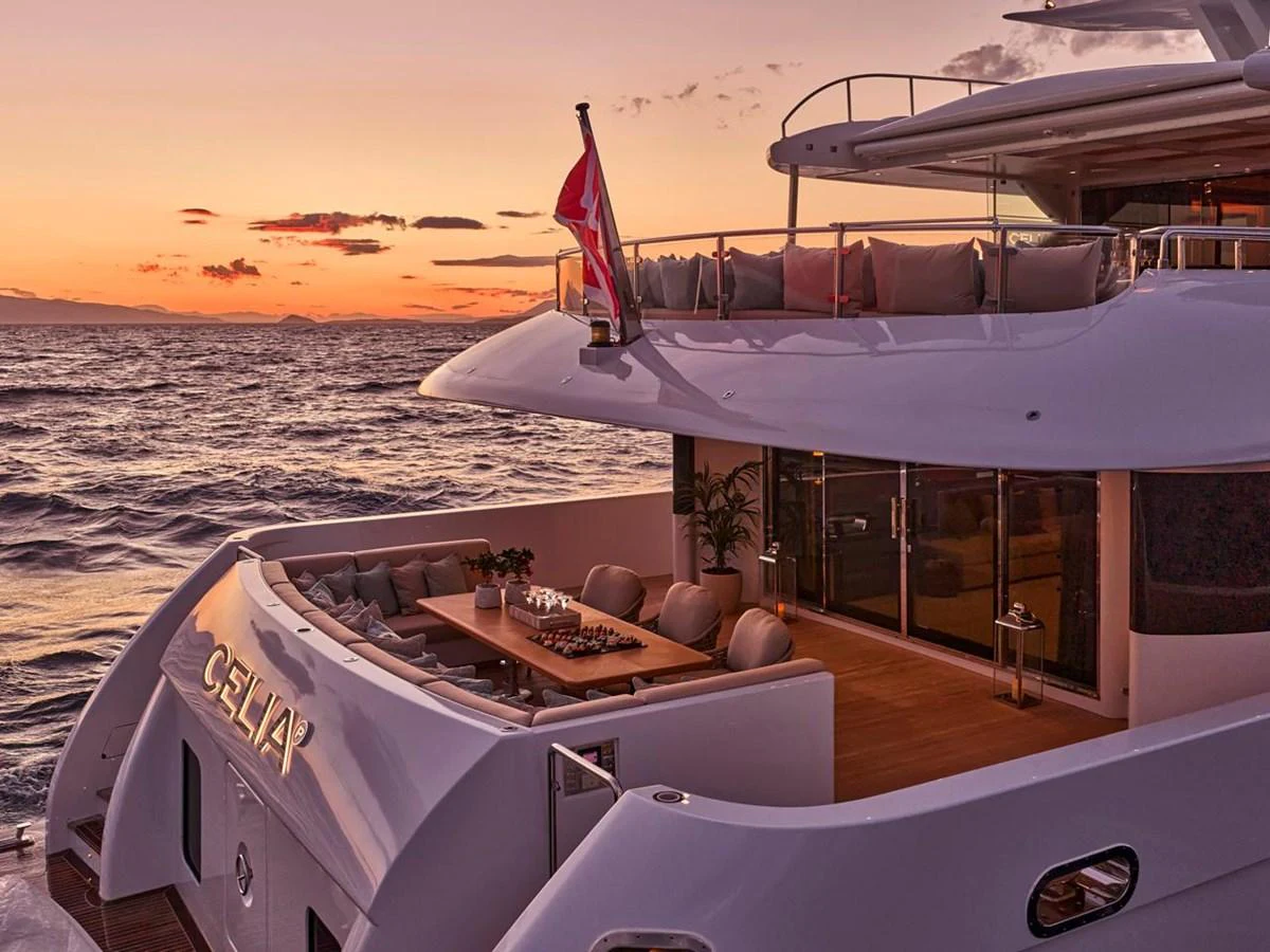 The yacht's aft deck offers a luxurious outdoor dining area with stunning sunset views over the water. aboard ULYSSES Yacht for Sale