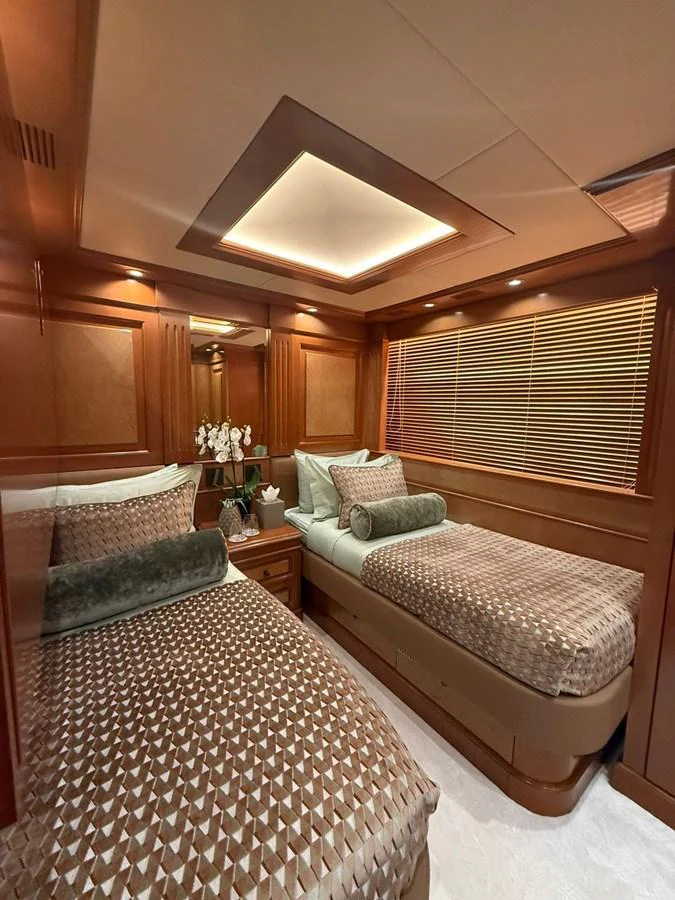 The twin stateroom offers a cozy and elegant retreat with warm wood finishes and plush bedding. aboard ULYSSES Yacht for Sale