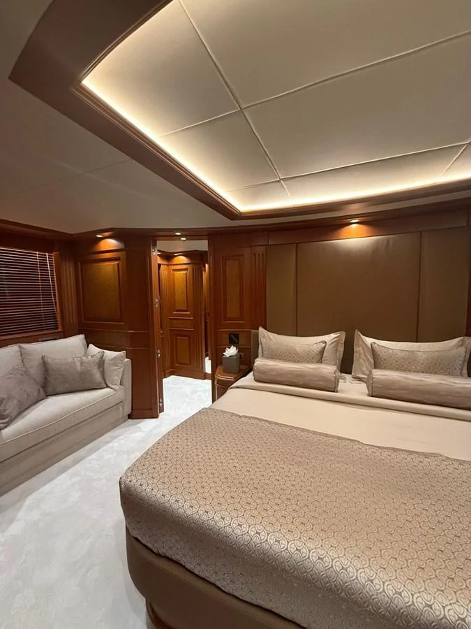 The master stateroom features luxurious bedding and elegant wood paneling, creating a serene and sophisticated atmosphere. aboard ULYSSES Yacht for Sale