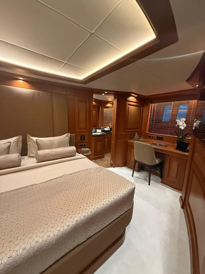 The stateroom features elegant wood paneling and a cozy, well-lit atmosphere. aboard ULYSSES Yacht for Sale