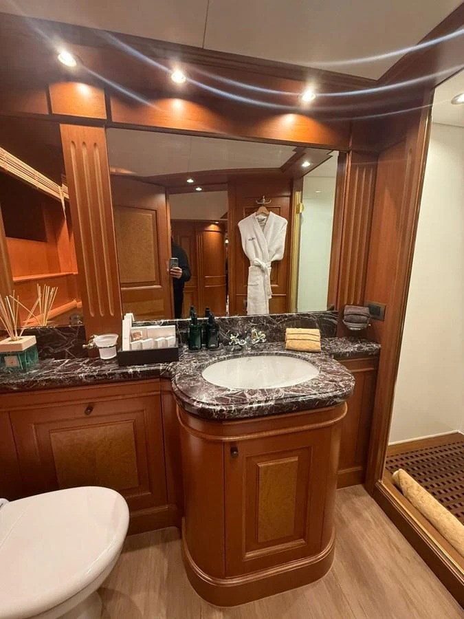 The yacht's bathroom features elegant wood cabinetry and a marble countertop. aboard ULYSSES Yacht for Sale