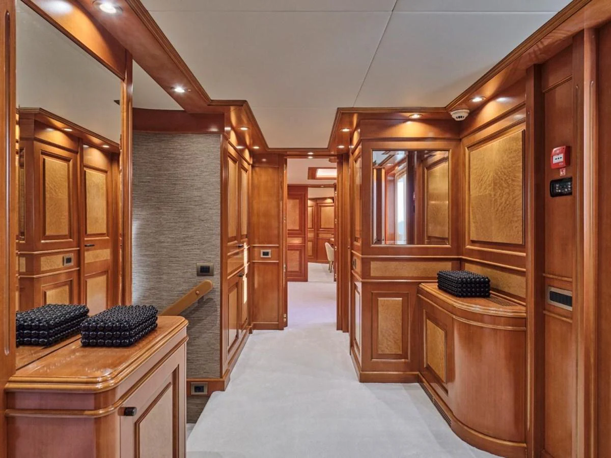 The yacht's interior features elegant wood paneling and luxurious finishes. aboard ULYSSES Yacht for Sale
