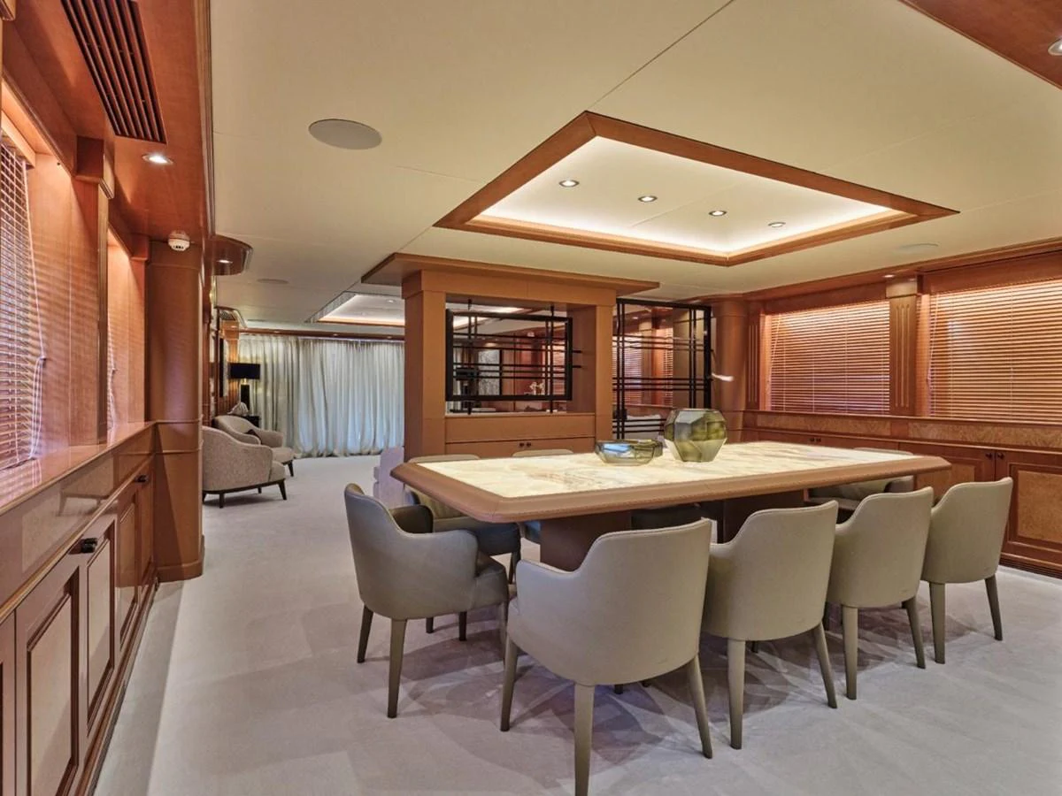 The yacht's dining area features a large table surrounded by comfortable chairs, ideal for elegant meals. aboard ULYSSES Yacht for Sale