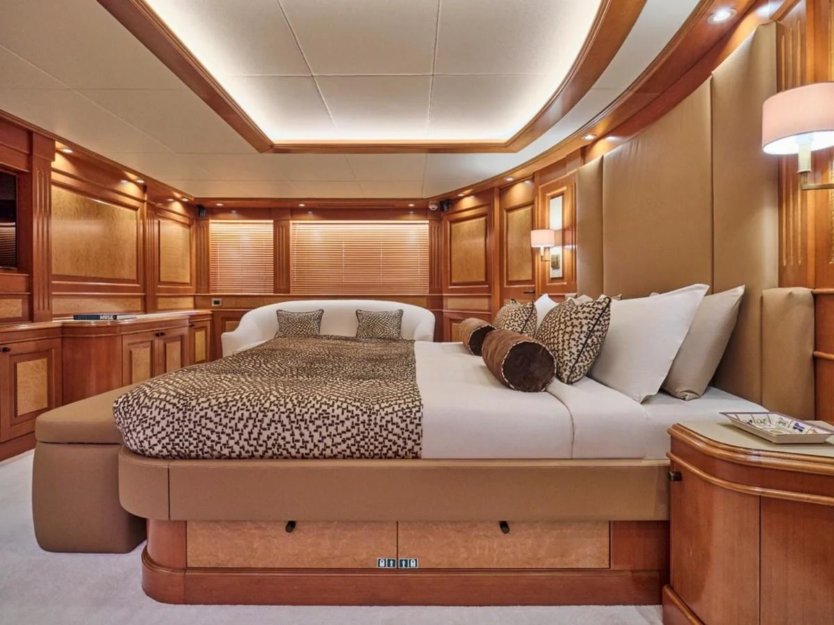 The master stateroom features luxurious bedding and elegant wood paneling. aboard ULYSSES Yacht for Sale