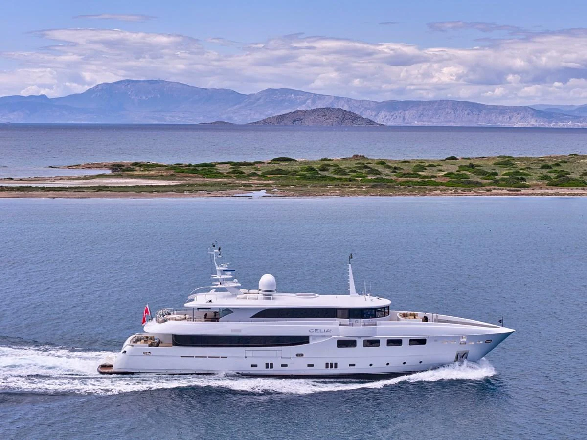 A sleek and modern yacht cruises gracefully along a serene coastline. aboard ULYSSES Yacht for Sale