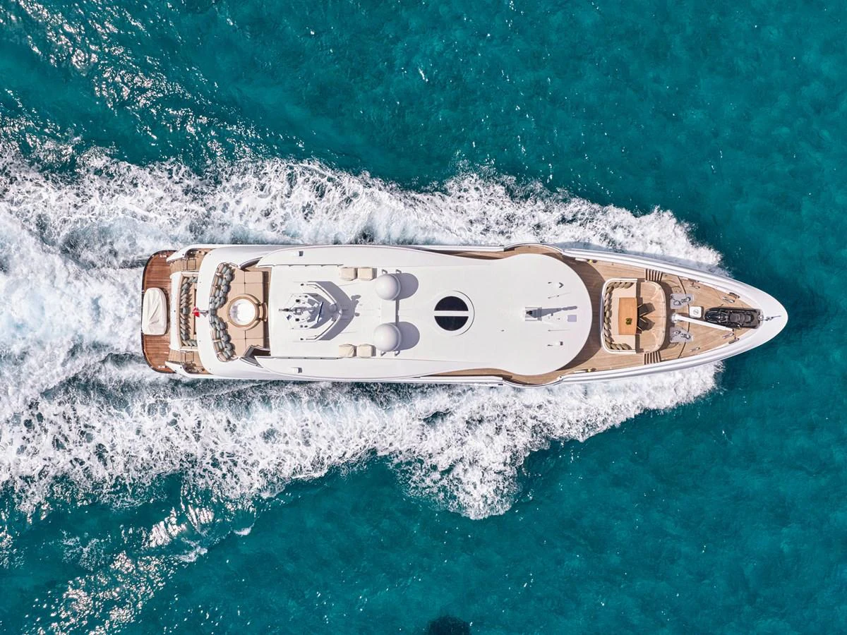 An aerial view of a luxurious yacht cruising through clear blue waters. aboard ULYSSES Yacht for Sale