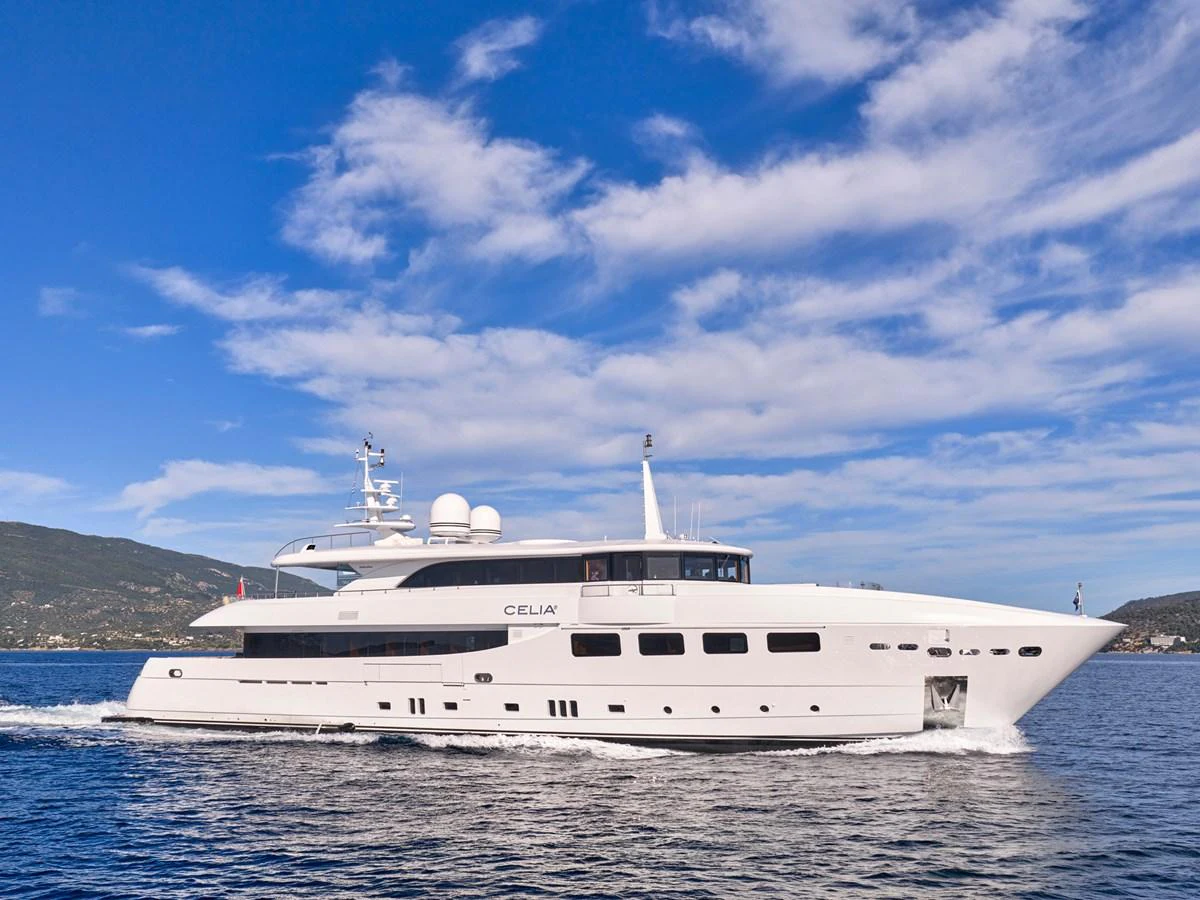 A sleek and modern yacht cruises gracefully on calm waters under a clear blue sky. aboard ULYSSES Yacht for Sale