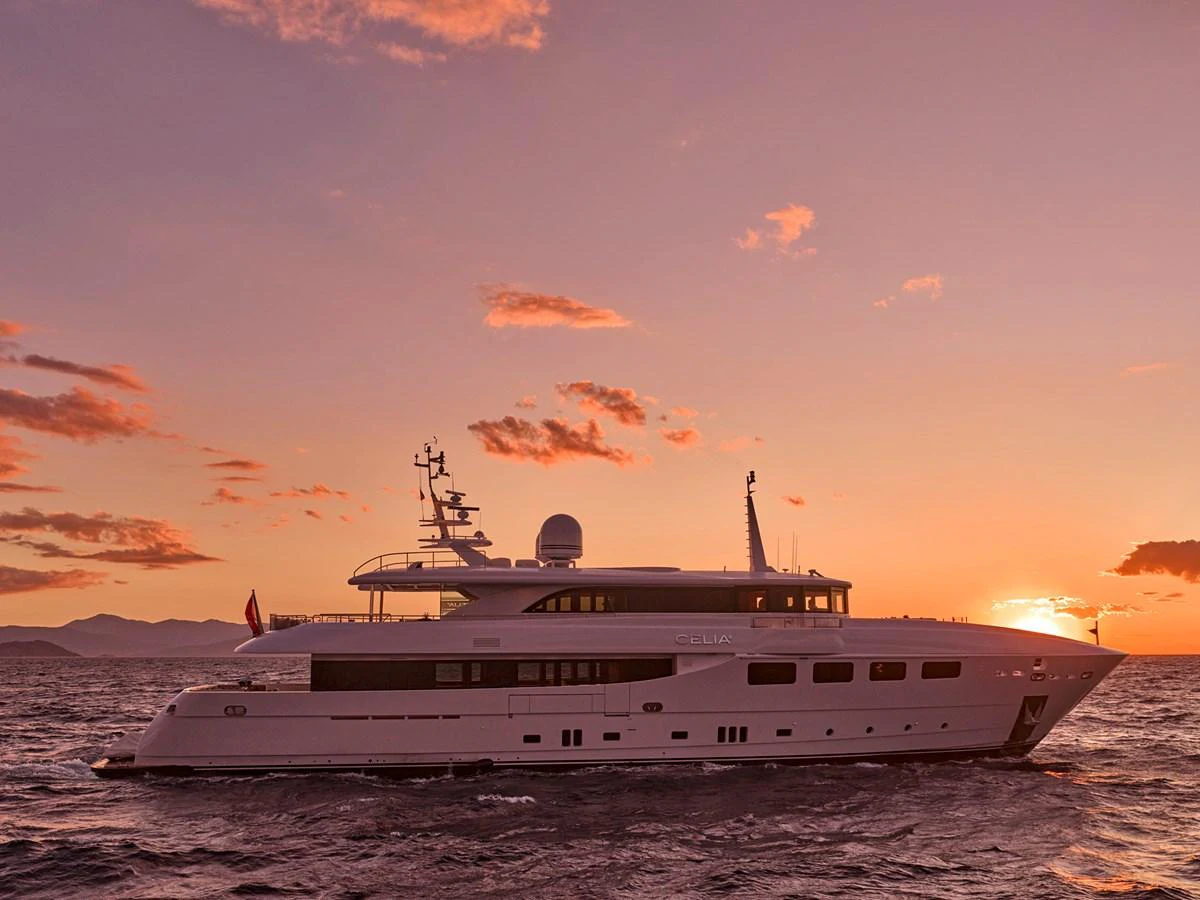 A luxurious yacht sails at sunset, showcasing its elegant design against a stunning backdrop. aboard ULYSSES Yacht for Sale