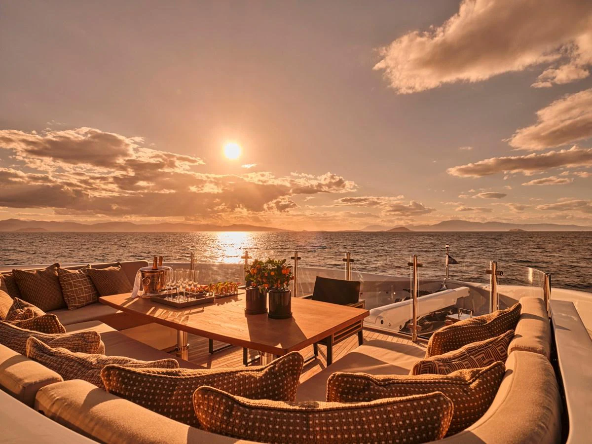 The aft deck offers a luxurious seating area with stunning sunset views over the water. aboard ULYSSES Yacht for Sale